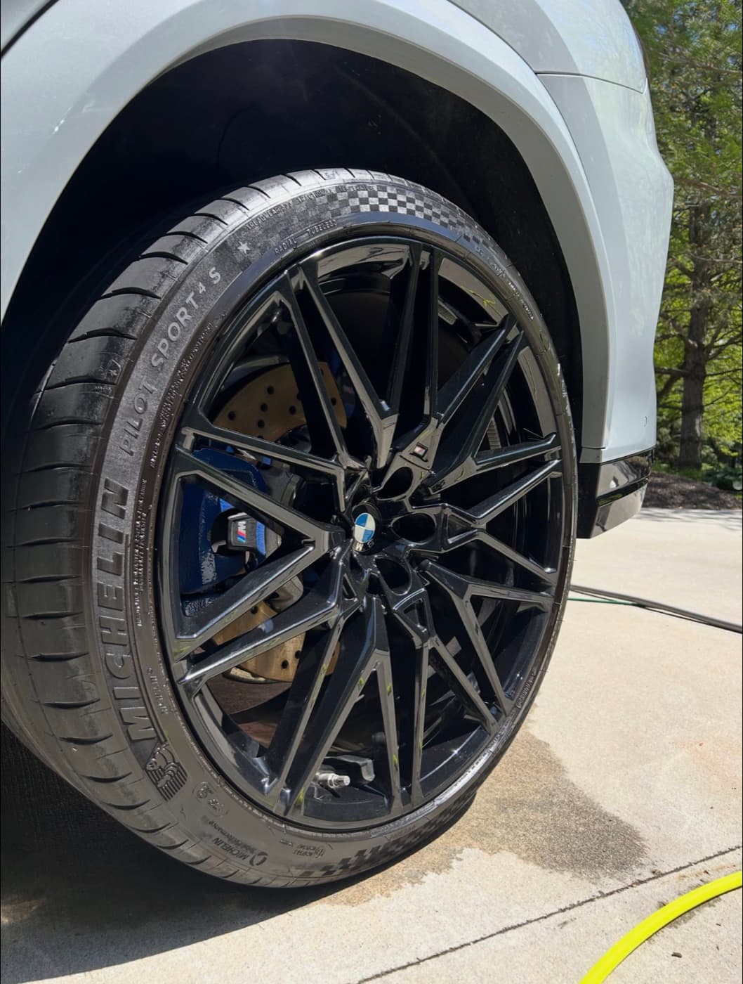 Close-up of a BMW wheel and tire after a ceramic coating with mirror-finish gloss on the wheel and paint